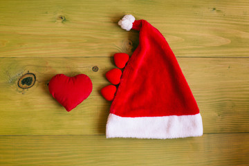 Obraz na płótnie Canvas Image of Santa Hat and hearts on wooden table.