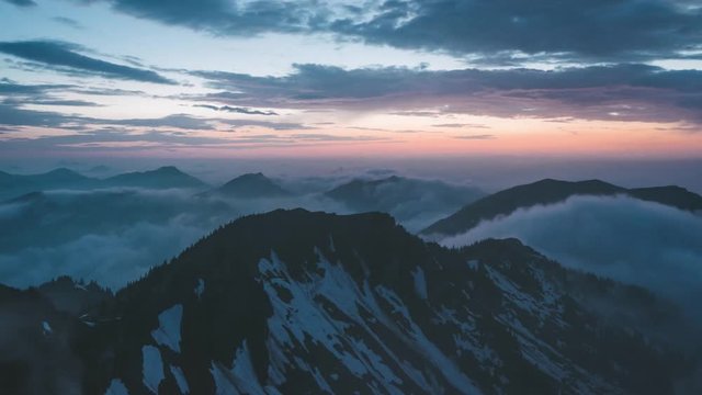 Sunset on top of mountain Rotwand  in the Bavarian Alps in Germany 4K time-lapse. Clouds are rushing by during golden hour on high altitude alpine scenery.