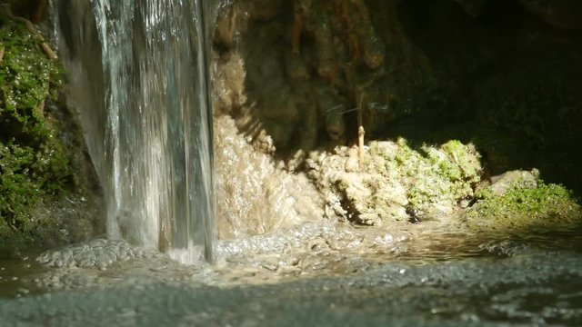 close up to the water flow into the pool in the limestone stream