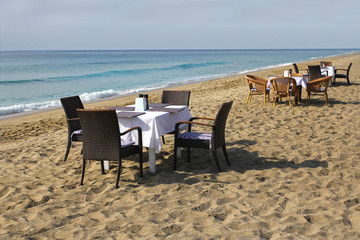 Table and chairs on the beach by the sea. Romantic concept. Marine Cafe.