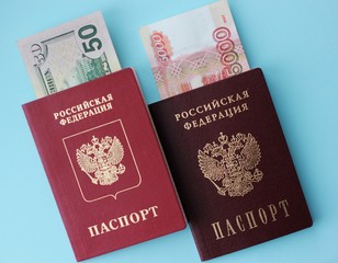 Russian money is 5,000 rubles, and Ameikans 50 dollars, a biometric passport and a passport of the Russian Federation on a colored background. The concept of travel abroad.