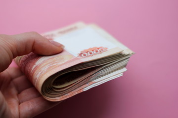 A stack of bills in denominations of 5000 rubles in hand. Russian money.Scissors cut a stack of 5,000 rubles bills in hand.