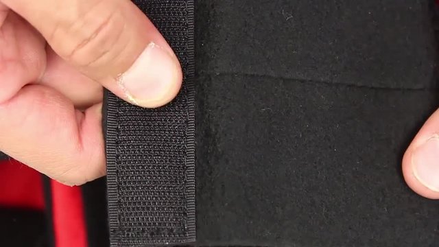 human hand testing pice of black soft material, with velcro