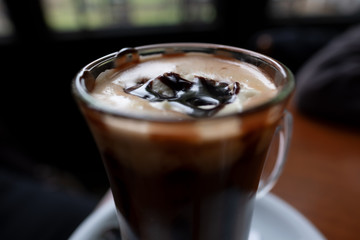 cup of coffee with cream on wooden background