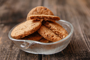 Integral cookies with cereal, dried fruit and chocolate on old wooden table