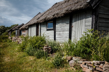 Fototapeta na wymiar Altes armes Bauernhaus aus Holz. Blockhaus mit Reetdach
