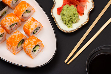 Uramaki California. Sushi rolls and plate with red pickled ginger and wasabi.