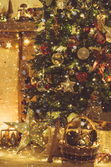 Beautiful warm interior, decorated fireplace with solid wood mantelpiece, lit up Christmas tree with baubles and ornaments, stars, lights, candles, toned, created snow, selective focus