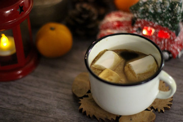 Coffee with marshmallow in a white cup on a blurred wooden background. In frame view a red lantern, mandarins. Holiday concept