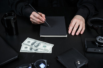 Businessman during work. Stylish black workplace. Dollars on the office desk.