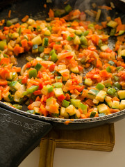 Making, cooking onion, red and green pepper and courgette in a frying pan