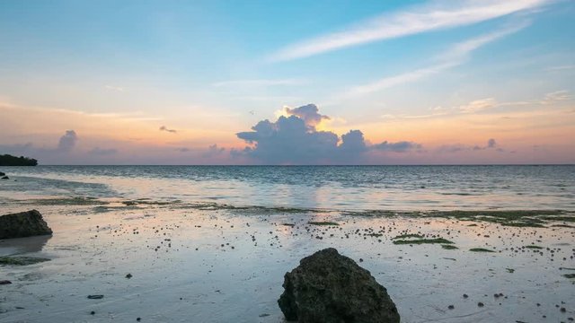 Time lapse tropical beach and sea at sunset. Colorful dramatic sky at dusk. Romantic passion concept. Tomia Island, Wakatobi national park, Indonesia.