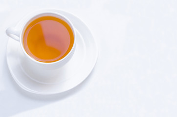 Orange herbal flavored christmas tea with cinnamon and cardamom honey white cup on a white wooden table