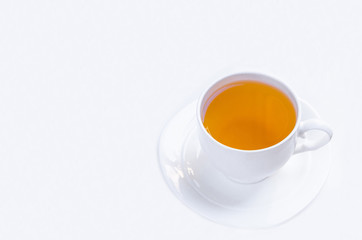 Orange herbal flavored christmas tea with cinnamon and cardamom honey white cup on a white wooden table