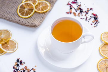 Orange herbal flavored christmas tea with cinnamon and cardamom honey white cup on a white wooden table