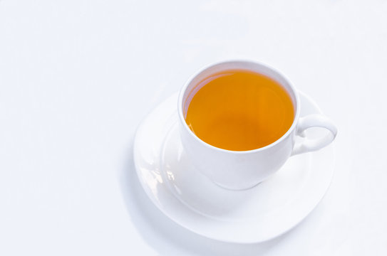 Orange herbal flavored christmas tea with cinnamon and cardamom honey white cup on a white wooden table
