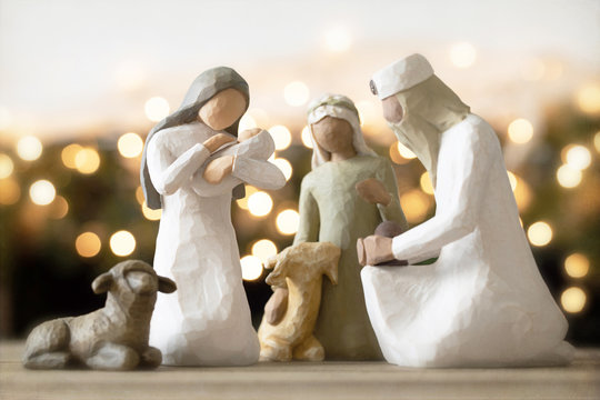 Christmas photograph of a nativity set with Mary, a king and a shepherd gazing at baby Jesus