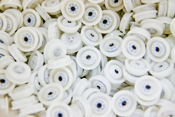 stack of one way white degassing plastic valves with bright light in packaging factory