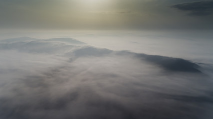 Aerial view from a drone about the Transylvanian valleys on a foggy morning, above Sic village,...