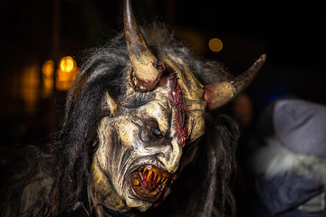 Closeup on horned devil in traditional krampuslauf with wooden masks in Retz, Austria. The Krampus is in the tradition of a fright figure in the company of St. Nicholas.