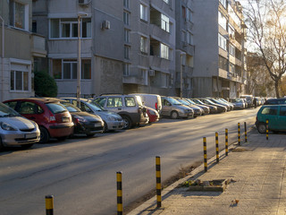 Many cars parked on the roadside in the sleeping area of a city in the evening. Cityscape in the winter evening.