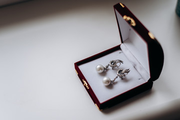 silver earrings with pearls in a red box