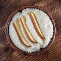 Mengrelian corn mamalica (ghomi) with cheese in ceramic dish (ketsi). Georgian traditional food
