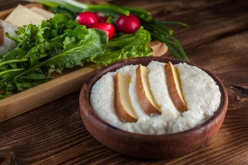 Mengrelian corn mamalica (ghomi) with cheese and various herb on wooden table. Georgian traditional food