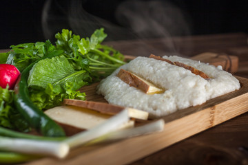 Mengrelian corn mamalica (ghomi) with cheese and various herb on wooden table. Georgian traditional food