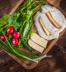 Mengrelian corn mamalica (ghomi) with cheese and various herb on wooden table. Georgian traditional food
