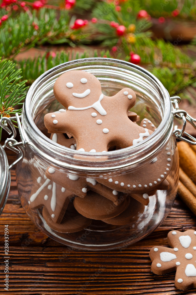 Poster Gingerbread Christmas cookies in a jar, cinnamon, hazelnuts and branch of spruce tree on wooden table