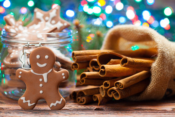 Cinnamon sticks and gingerbread Christmas cookies on lighting background
