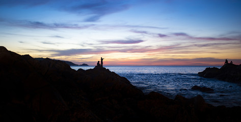 Silhouette of two fisherman at sunset in Phuket, Thailand