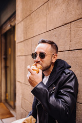 Young man eating on the street