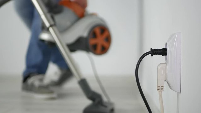 Blurred Image with Employee Using Vacuum Cleaner Cleaning the Floor Inside Room