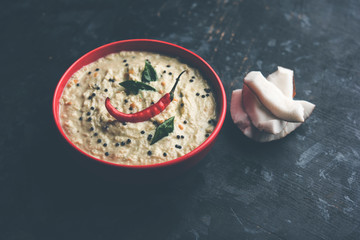 Nariyal or Coconut Chutney served in a bowl. Isolated over moody background. selective focus