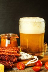 Beer and sausages on an old wooden table. Sale of beer and sausage. Food for beer. Unhealthy food.