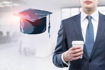 Businessman in office, graduation hat
