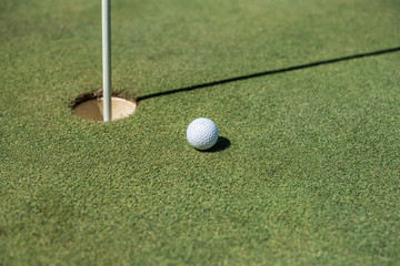 Golf field with white ball near the hole