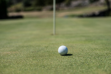 Golf field with white ball near the hole