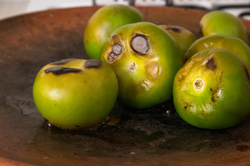 Roasting Tomatillos on a Comal in Mexico City (close-up)