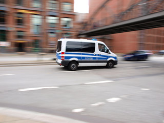 Plakat Polizeiauto auf Streife in der Hafencity Hamburg | Bewegungsunschärfe