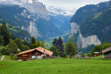 Fototapeta na wymiar Mountain dramatic valley view with wooden rustic house in Wengen in Lauterbrunnen region in Switzerland.