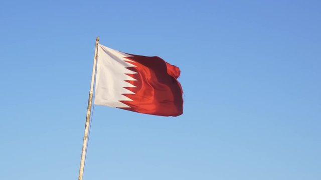 Qatari national flag, with its fields of white and red divided by jagged line