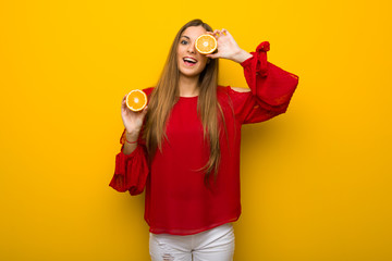 Young girl  on vibrant yellow background with oranges