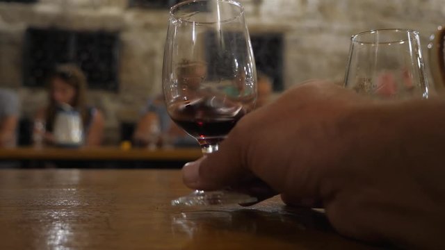 Wine tasting in the tasting room. Excursion around the winery of Crimea. Bakaly stand on the table. Wine is poured into a glass dish. Sommelier extends his hand to his glass. 4K. SUNNY VALLEY