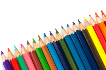 Color pencils pink light blue green yellow and red on white background.