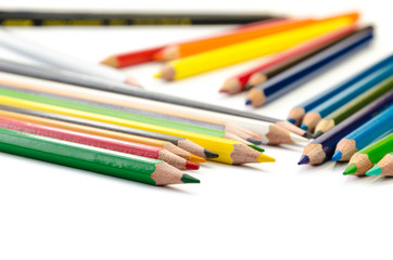 Color pencils pink light blue green yellow and red on white background.