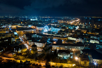Obraz premium Night cityscape of Kiev. View of Podil with ferris wheel in the center