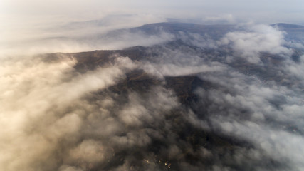 Aerial view from a drone about the Transylvanian valleys on a foggy morning, above Sic village, Transylvania,  Romania